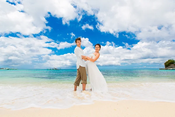 Happy groom and bride having fun on the sandy tropical beach. We — Stock Photo, Image