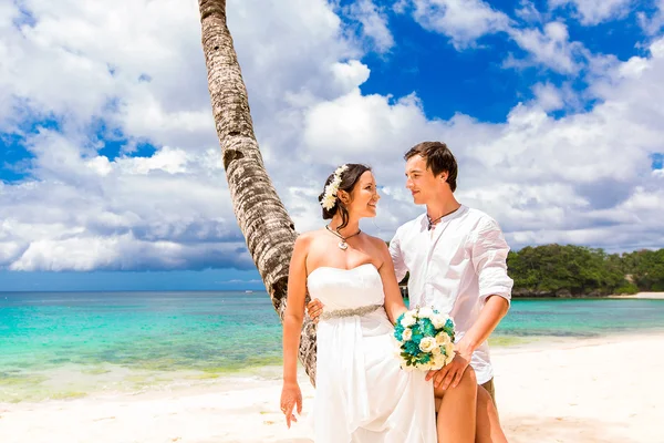 Feliz novio y novia divirtiéndose en la playa tropical de arena. Nosotros... —  Fotos de Stock