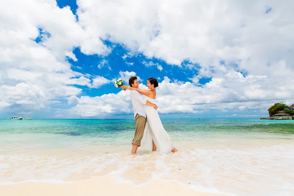 Happy groom and bride having fun on the sandy tropical beach. We — Stock Photo, Image