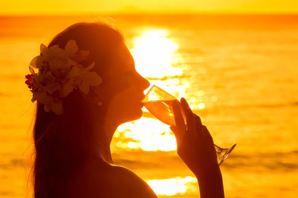 Foto silhueta de uma mulher bebendo champanhe de um copo em s — Fotografia de Stock