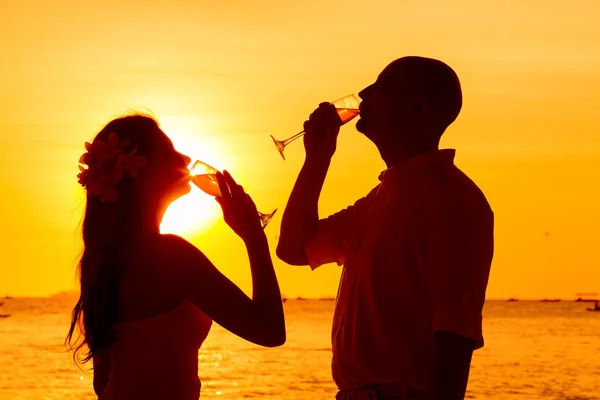 Silhouette of couple enjoying glass of champagne on tropical bea — Stock Photo, Image