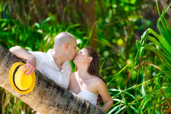 Happy bride and groom having fun on a tropical jungle — Stock Photo, Image