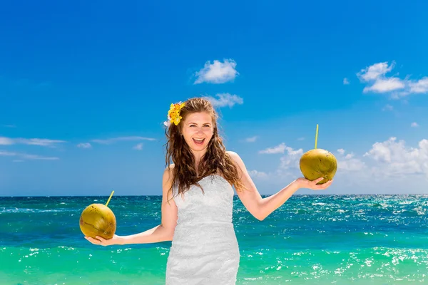 Happy laughing bride having fun on a tropical beach holding a tw — Stock Photo, Image