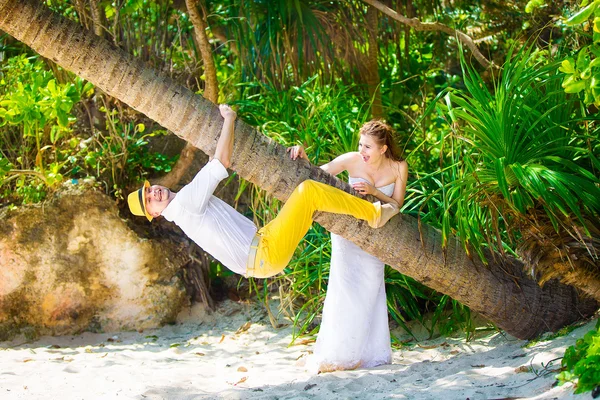 Happy bride and groom having fun on a tropical jungle — Stock Photo, Image