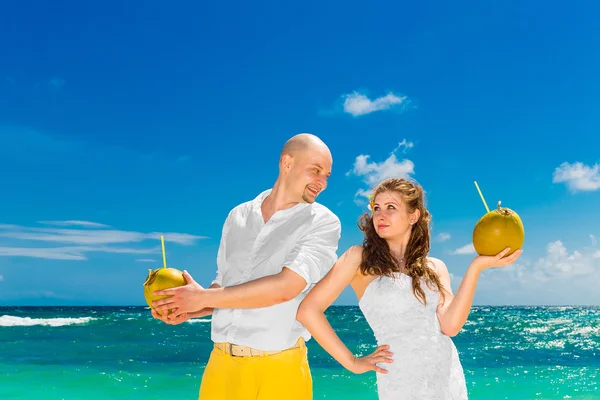 Ευτυχισμένη νύφη και τον γαμπρό να πίνουν νερό καρύδας σε μια τροπική παραλία. W — Φωτογραφία Αρχείου