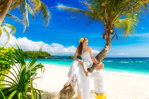 Happy groom and bride having fun on the sandy tropical beach und — Stock Photo, Image
