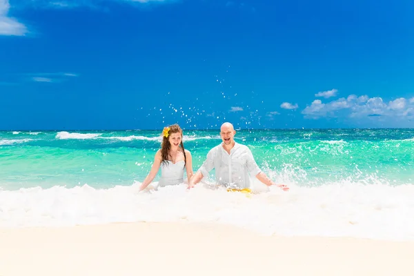 Lyckliga bruden att ha kul på en tropisk strand. Bröllop och honeymoo — Stockfoto