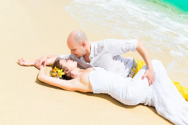 Lyckliga bruden och brudgummen att ha kul på en tropisk strand. Bröllop en — Stockfoto