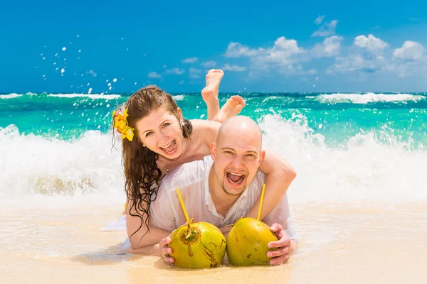 Lyckliga bruden och brudgummen att ha kul på en tropisk strand. Bröllop en — Stockfoto