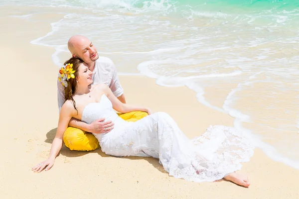 Gelukkige bruid en bruidegom plezier op een tropisch strand. Bruiloft een — Stockfoto
