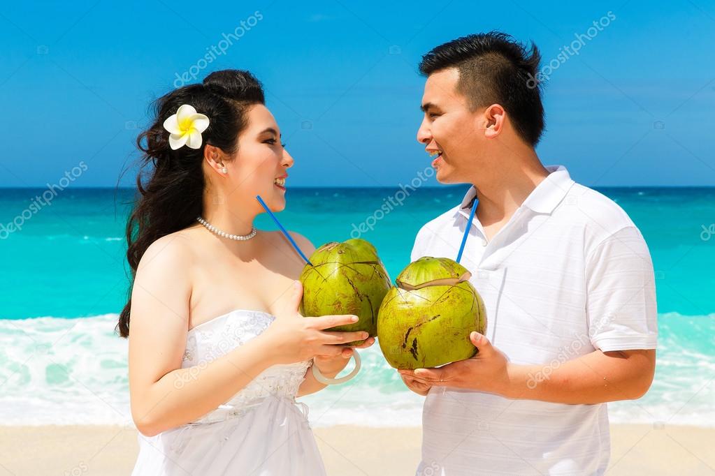 Asian bride and groom on a tropical beach. Wedding and honeymoon