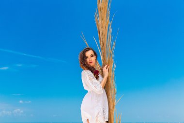 Mutlu genç esmer beyaz elbise sianding palm ile yaprak