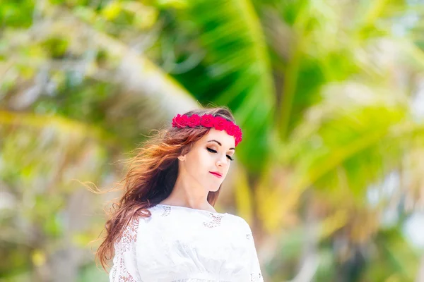 Young beautiful woman relaxing under the palm tree in a hotel on — Stock Photo, Image