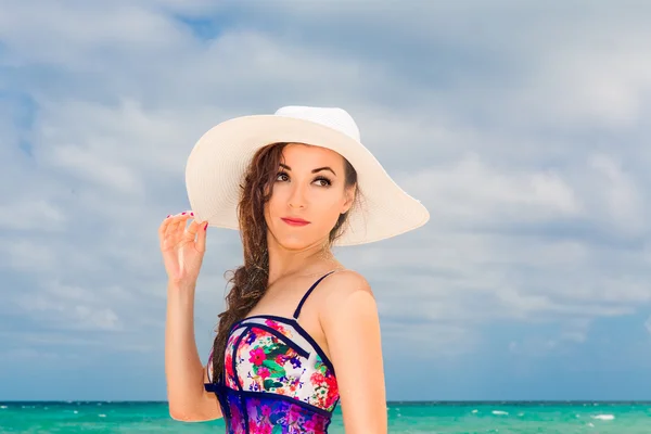 年轻漂亮的女孩，在一顶白色草帽进港的海滩上 — 图库照片