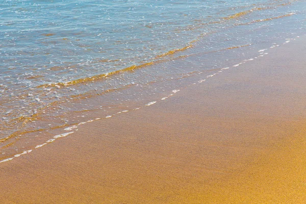 Fechar a espuma do mar na areia dourada molhada com espaço de cópia — Fotografia de Stock