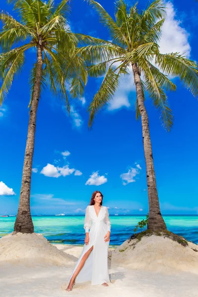Jovem mulher bonita em vestido branco sob as palmeiras em um h — Fotografia de Stock