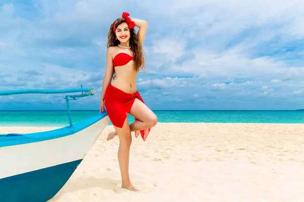 Pin hasta hermosa mujer joven en bikini rojo en una playa tropical . —  Fotos de Stock