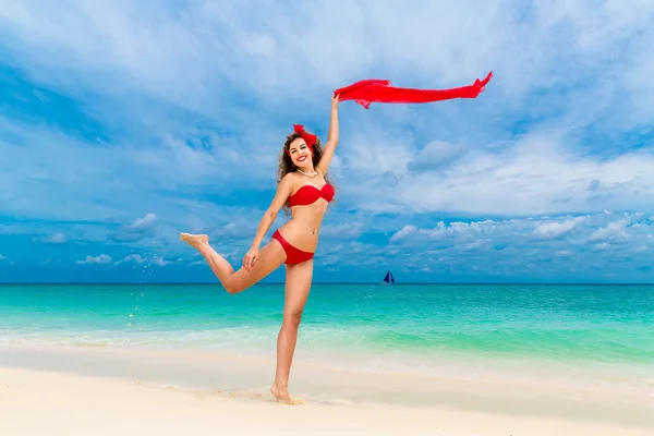 Pin up bella giovane donna in bikini rosso su una spiaggia tropicale . — Foto Stock