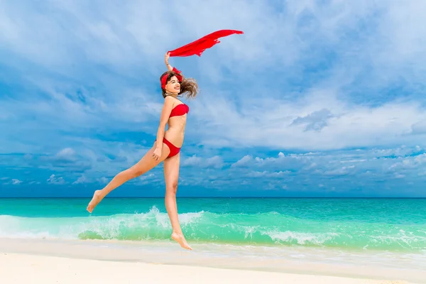 Pin up bella giovane donna in bikini rosso su una spiaggia tropicale . — Foto Stock