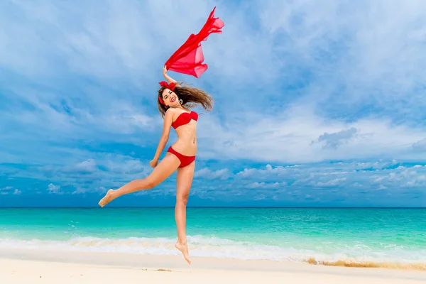 Pin up kaunis nuori nainen punaisissa bikineissä trooppisella rannalla . — kuvapankkivalokuva
