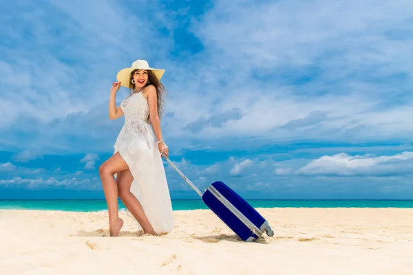 Beautiful young woman in white dress and straw hat with a suitca — Stockfoto