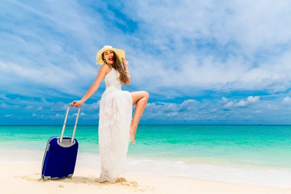 Beautiful young woman in white dress and straw hat with a suitca — Stockfoto