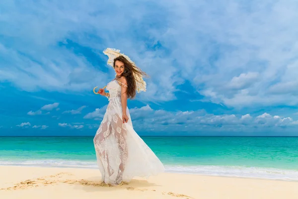 Beautiful young woman in white dress with umbrella on a tropical — 图库照片