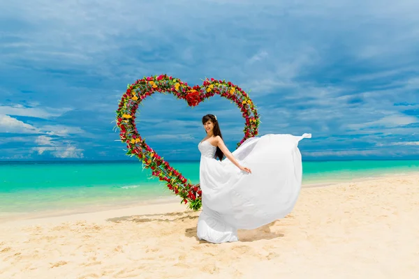 Trauung an einem tropischen Strand. glückliche Braut unter dem Hochzeitskleid — Stockfoto