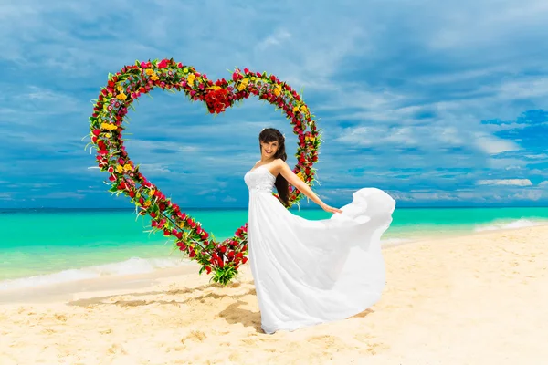 Trauung an einem tropischen Strand. glückliche Braut unter dem Hochzeitskleid — Stockfoto