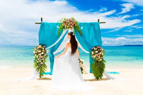 Cerimônia de casamento em uma praia tropical. Noiva feliz sob o casamento — Fotografia de Stock