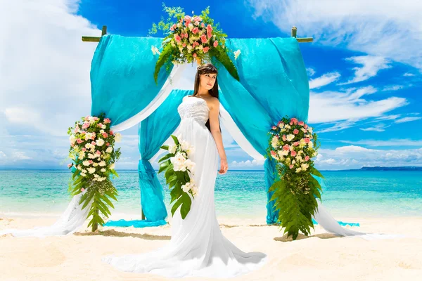 Cérémonie sur une plage tropicale. Heureuse mariée sous le wedd — Photo