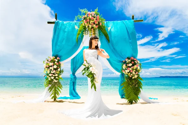 Wedding ceremony on a tropical beach. Happy bride under the wedd — Stok fotoğraf