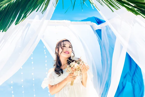 Cerimonia nuziale su una spiaggia tropicale in blu. Sposa felice con un — Foto Stock