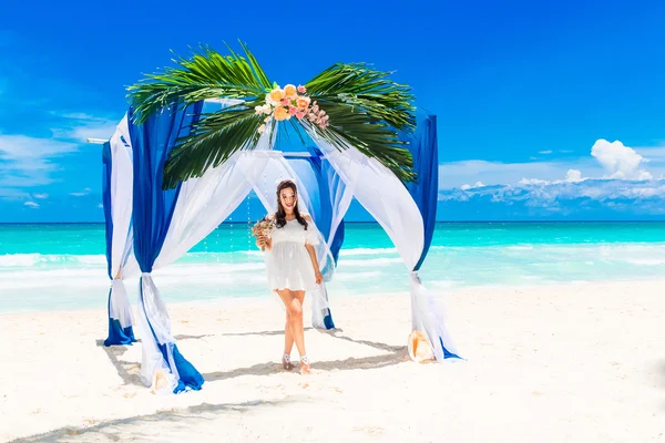 Wedding ceremony on a tropical beach in blue. Happy bride with a — Stock fotografie