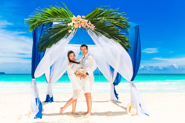 Ceremonia de boda en una playa tropical en azul. novio feliz y br — Foto de Stock