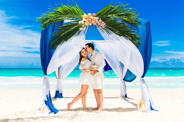 Wedding ceremony on a tropical beach in blue. Happy groom and br — Stock Photo, Image