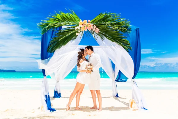 Ceremonia de boda en una playa tropical en azul. novio feliz y br —  Fotos de Stock