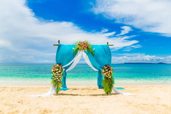 Wedding ceremony on a tropical beach in blue. Arch decorated wit Stock Image