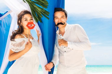Mavi bir tropik sahilde düğün töreni. Mutlu damat ve br
