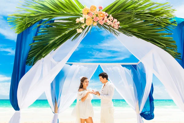 Groom giving an engagement ring to his bride under the arch deco — Stock Photo, Image