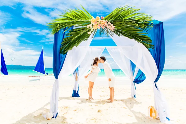 Ceremonia de boda en una playa tropical en azul. novio feliz y br — Foto de Stock