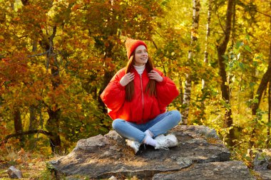Pozitif kızıl saçlı kadın doğada temiz havanın tadını çıkarıyor.