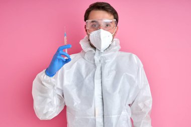 Şırıngalı beyaz önlüklü genç erkek doktor, ilaç konsepti