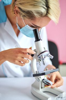 Kadın bilim adamı bilim ya da tıbbi araştırmayı elinde tutuyor