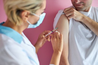 Kadın doktor şırıngayı dava ediyor. Hastanedeki adama aşı veriyor.