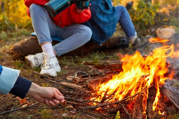 close-up photo of male hands trying to light a fire during a trip, adventure