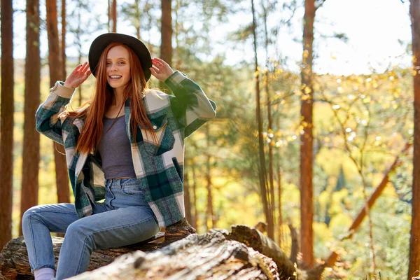 Привлекательная кавказская женщина с естественными рыжими волосами расслабляющая в лесу — стоковое фото