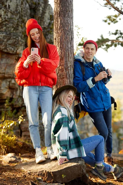 three caucasian friends enjoy spending time in the forest after climbing mountains