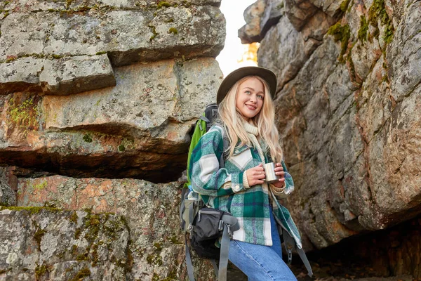 Encantador loira fêmea está bebendo chá quente durante caminhadas — Fotografia de Stock