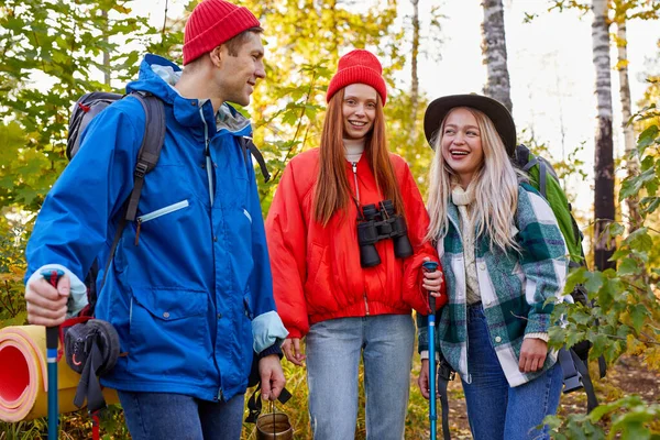 Üç beyaz arkadaş mola verir, ormanda yürüyüş sırasında konuşurlar. — Stok fotoğraf